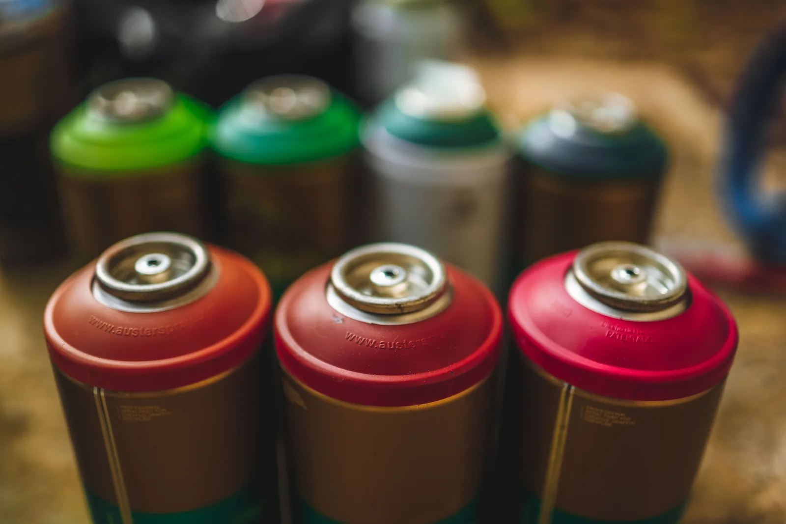 Close-up image of colorful spray paint cans arranged in a row, showcasing creativity and urban art. Parking lot striping hiring and crew training