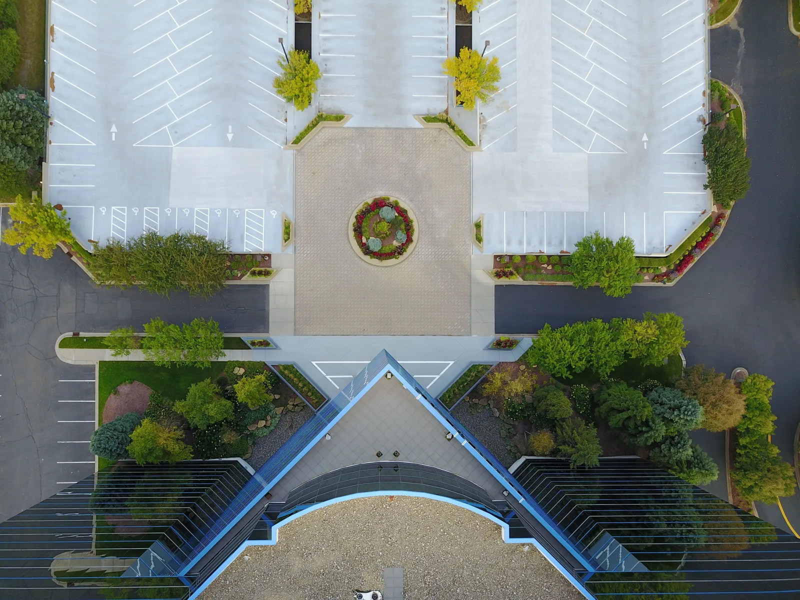 Top-down view of a modern building and empty parking lot, showcasing symmetry and urban design. Parking lot striping winter shutdown Canada: a spring startup checklist