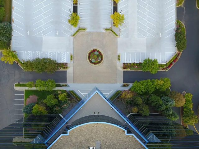 Top-down view of a modern building and empty parking lot, showcasing symmetry and urban design. Parking lot striping winter shutdown Canada: a spring startup checklist